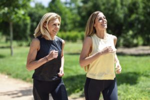 Mature woman running with her daughter in a park